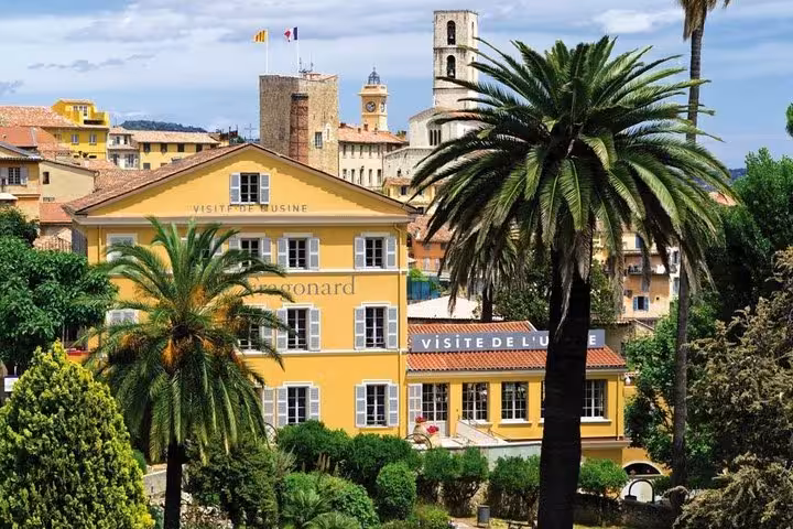 Yellow Fragonard perfume factory building with palm trees in Grasse, France