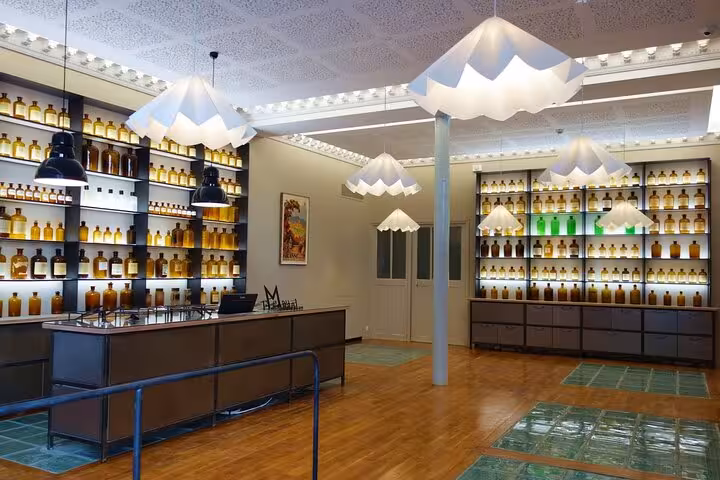 Elegant interior of Fragonard Perfume Factory featuring shelves lined with perfume bottles and modern lighting.