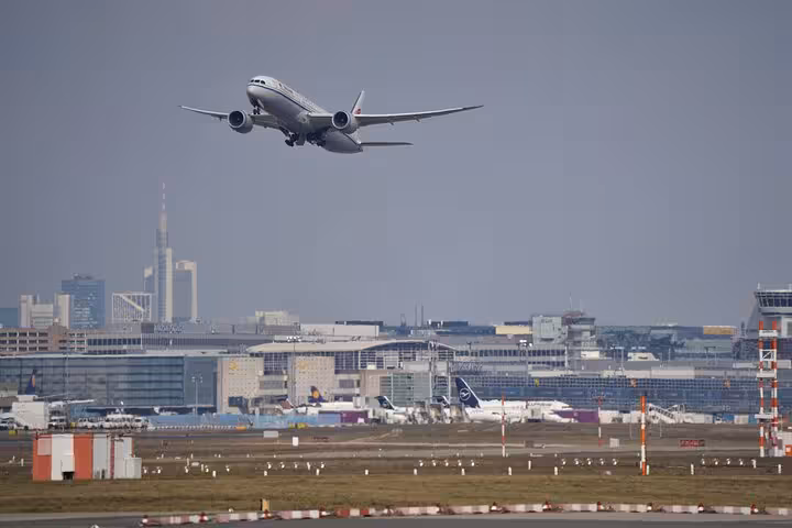 Airplane taking off from Frankfurt Airport with city skyline and terminal buildings in background
