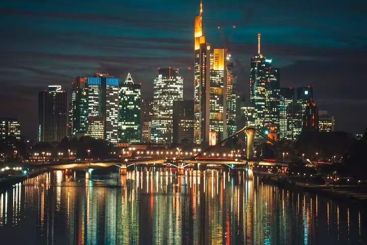 Frankfurt skyline at night with illuminated skyscrapers reflecting on the Main River