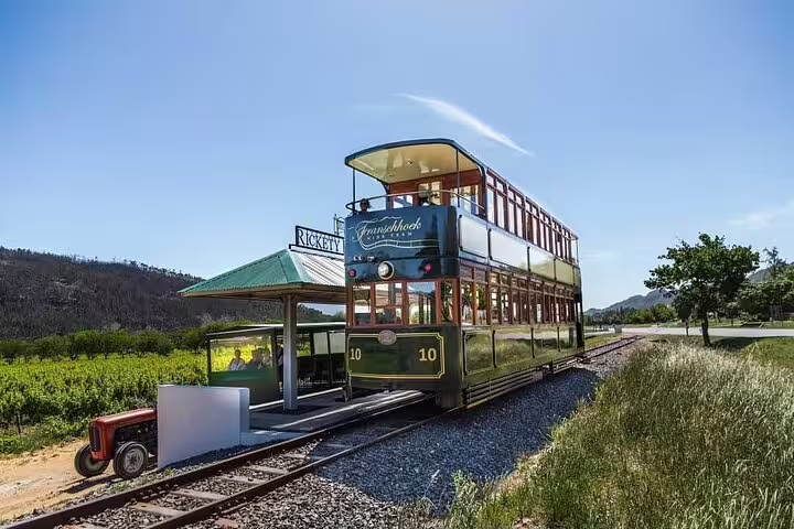 Franschhoek Tram at Rickety Bridge station, showcasing scenic vineyard views on the popular Explorer Tour in South Africa.