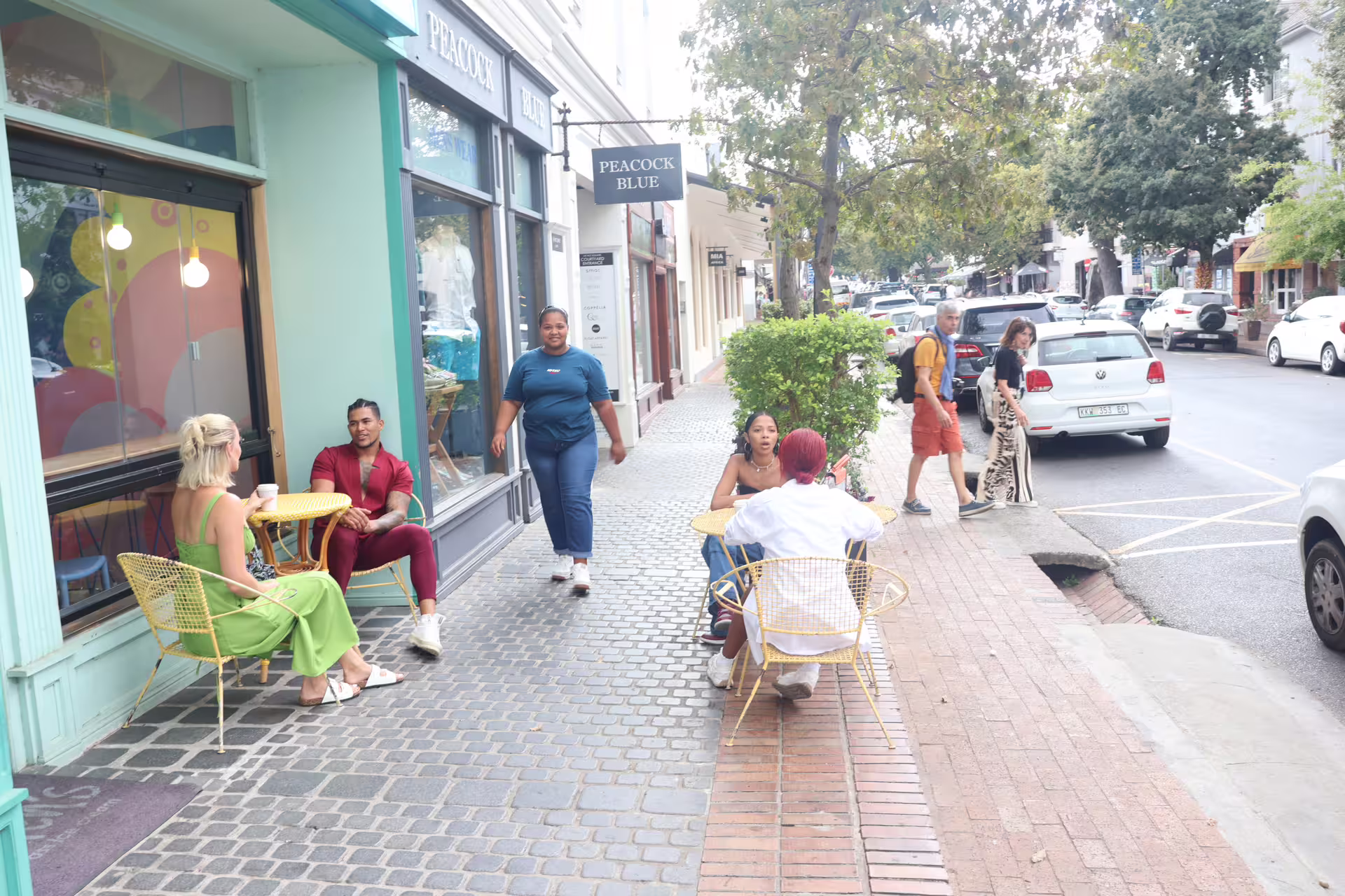 Relaxing outdoor café scene on a bustling street in Stellenbosch during the Franschhoek wine tram tour.