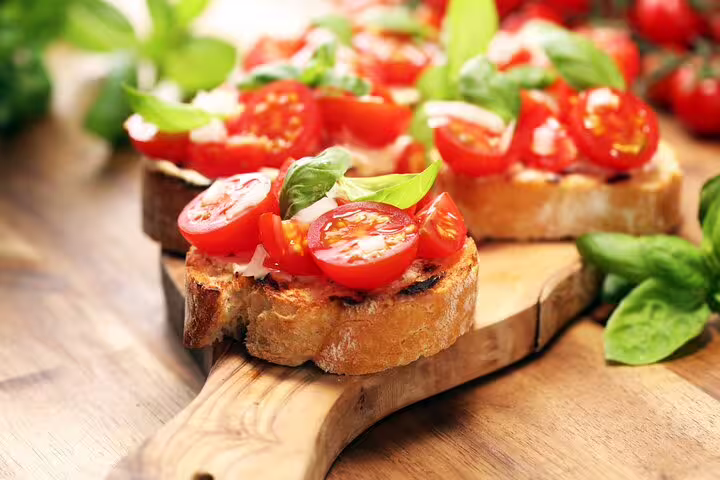 Fresh bruschetta with tomatoes and basil served on a rustic wooden board, perfect for a Frascati vineyard day trip lunch.