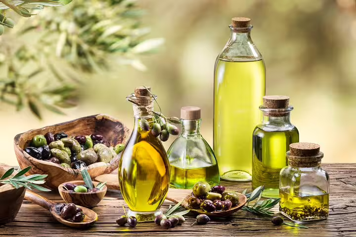 Assorted olive oils and fresh olives on a rustic table, capturing the essence of a Frascati vineyard culinary experience.