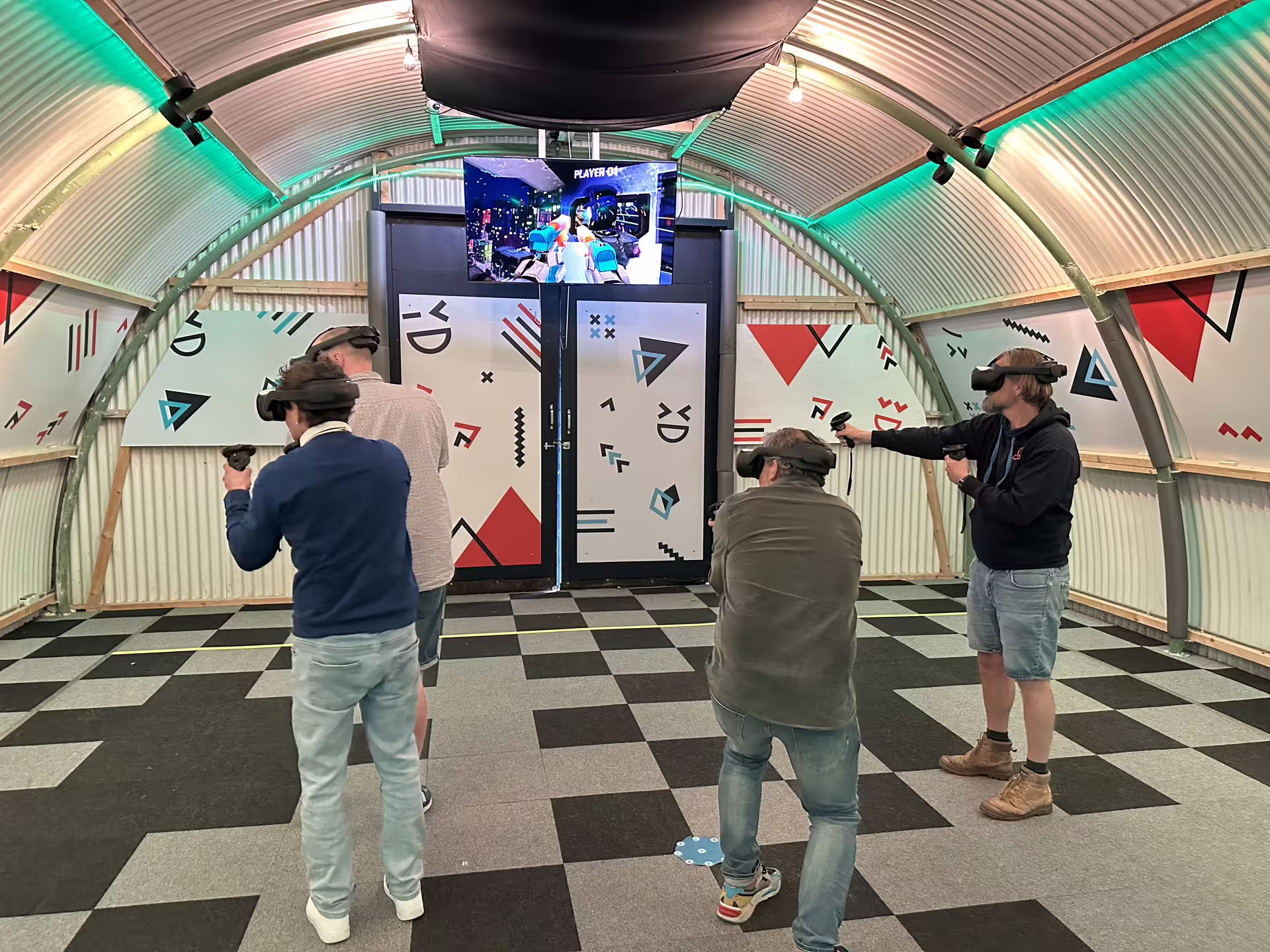 Friends playing Free Roam VR in Amsterdam arena, wearing headsets and controllers in immersive gaming space