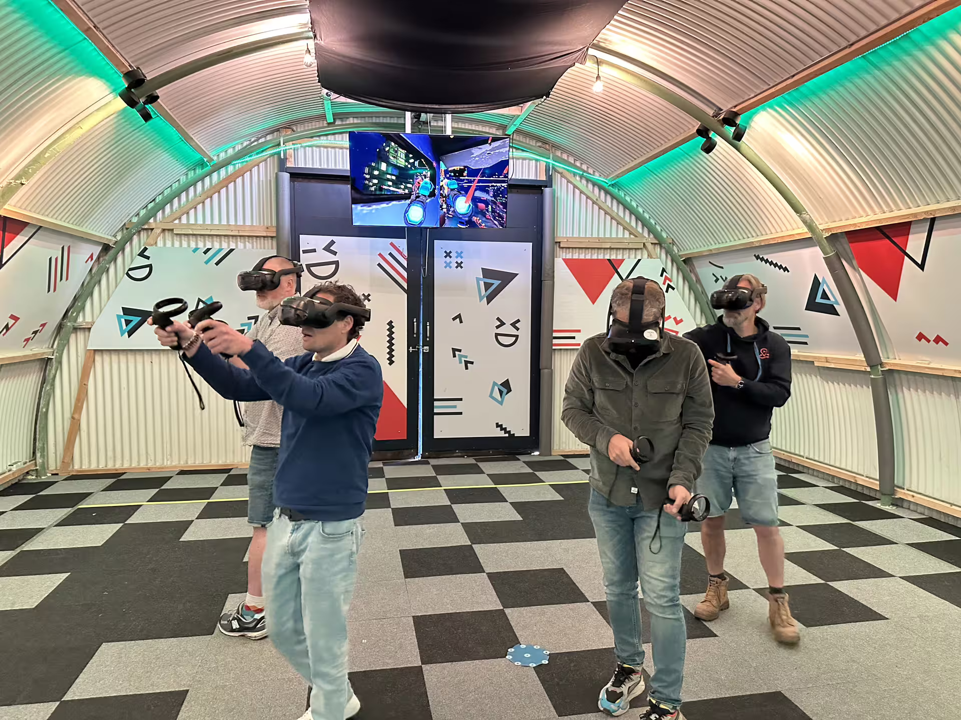 Group playing Free Roam VR Experience in Amsterdam with headsets and controllers in an indoor arena