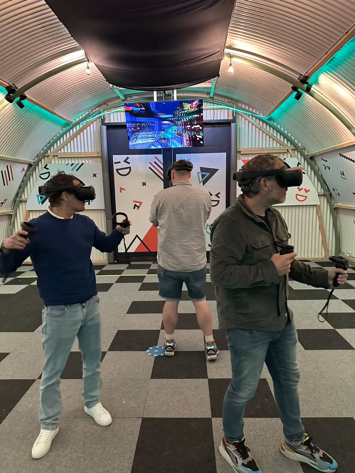 Visitors playing Free Roam VR in Amsterdam, wearing headsets and controllers in an immersive arena