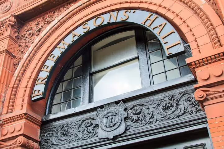 Ornate red brick Freemasons' Hall entrance with decorative stone archway and carved crest