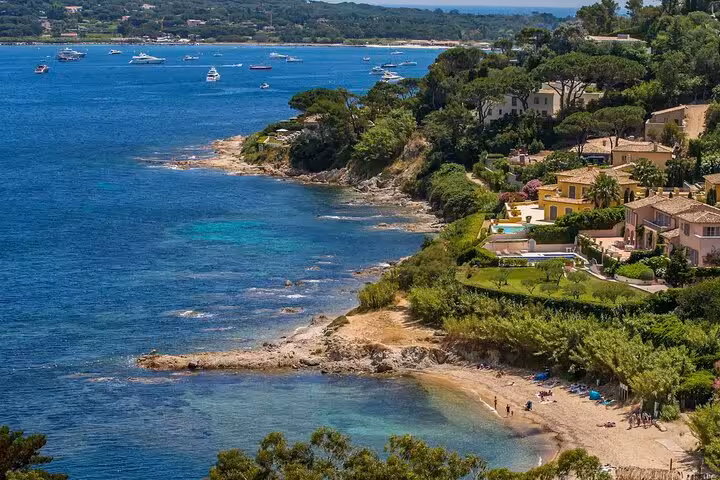 Aerial view of French Riviera coastline with turquoise waters, luxury villas, and yachts near Cannes