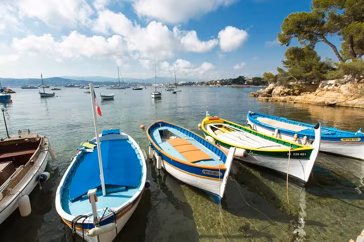 Colorful traditional boats moored in a calm bay on the French Riviera with sailboats in the background