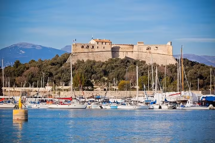 Historic fort overlooking a marina with sailboats on the French Riviera under a clear blue sky