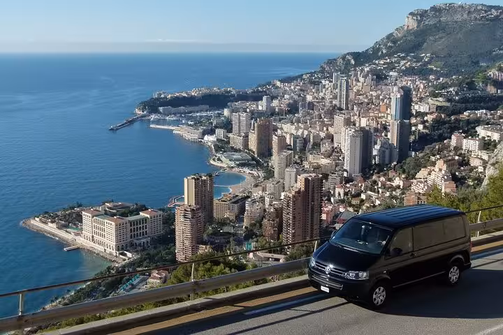 Black van on scenic overlook above Monaco coastline and city skyline on French Riviera
