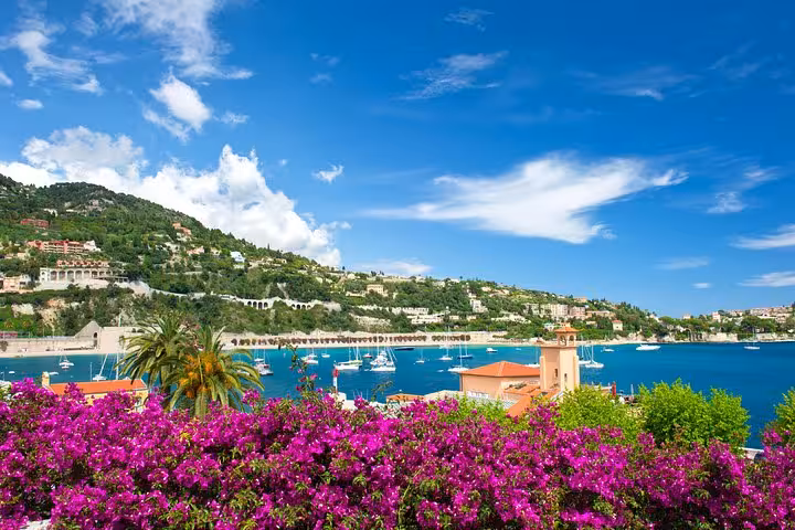 Villefranche-sur-Mer harbor with colorful bougainvillea, sailboats, and hillside villas on the French Riviera