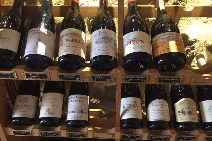 Selection of local French wine bottles on a cellar rack, featured in a 3-day heritage, wines and gastronomy tour