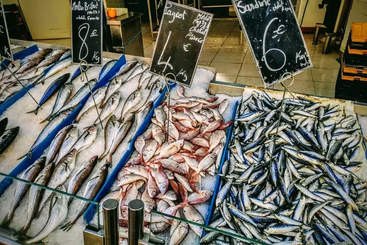 Fresh fish stall at Noailles market in Marseille, sardines and local catch on ice with price boards