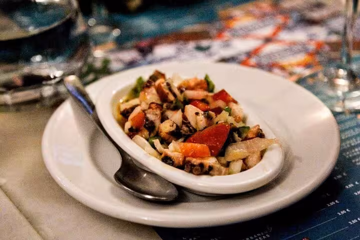 Plate of fresh octopus salad with vibrant vegetables on the Taste of Marbella Food Tour.