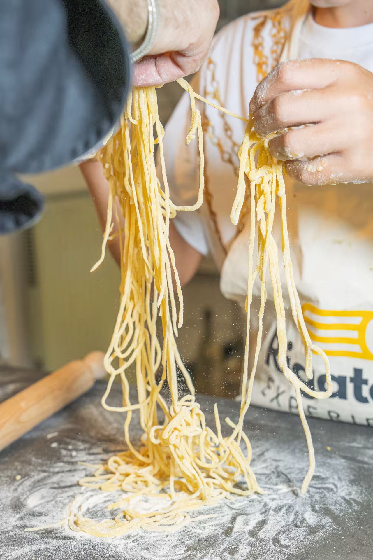 Hands preparing fresh pasta dough during a culinary class in the Italian Riviera's pesto experience tour.