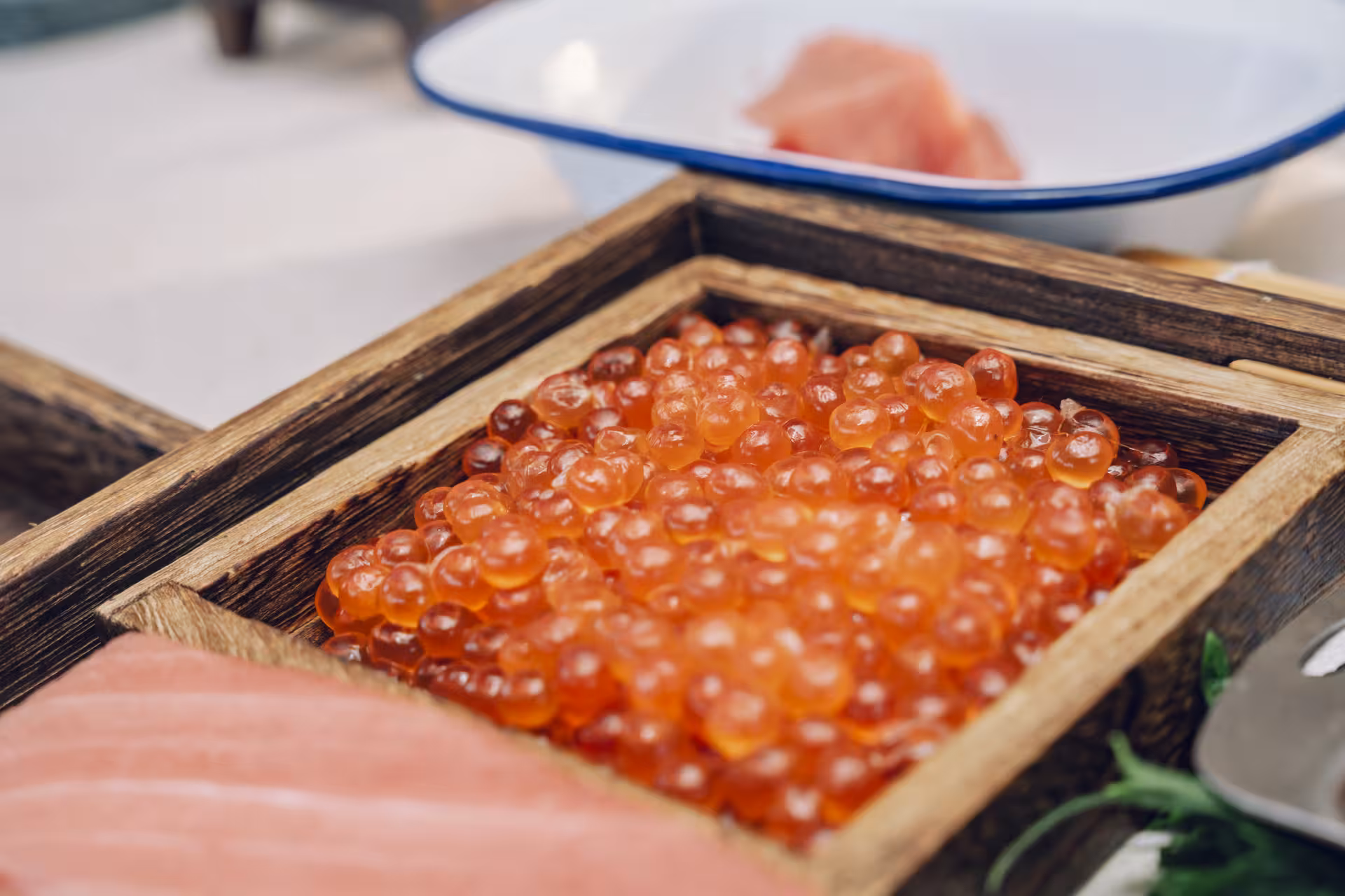Fresh salmon roe (ikura) in a wooden tray, premium ingredients showcased in a hands-on Sushi Masterclass
