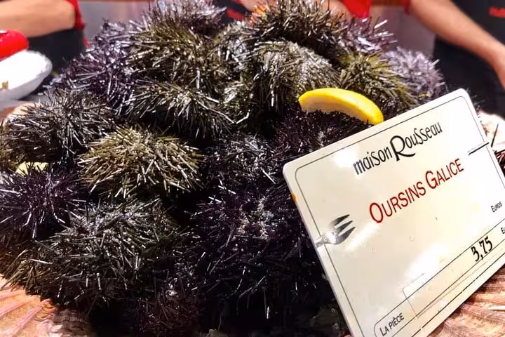 Fresh sea urchins displayed with a price tag at Maison Rousseau in Les Halles Paul Bocuse, Lyon market tour.