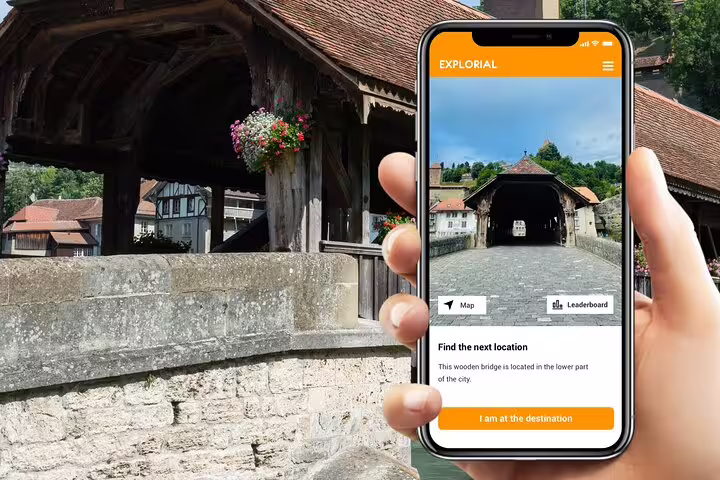 Self-guided Fribourg scavenger hunt app showing covered wooden bridge and sights tour navigation in Switzerland