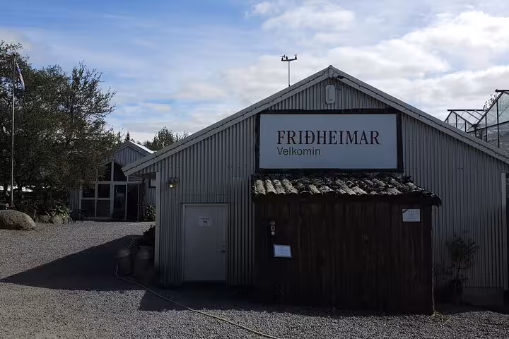Friðheimar farm entrance with welcome sign on corrugated metal building, Golden Circle Iceland