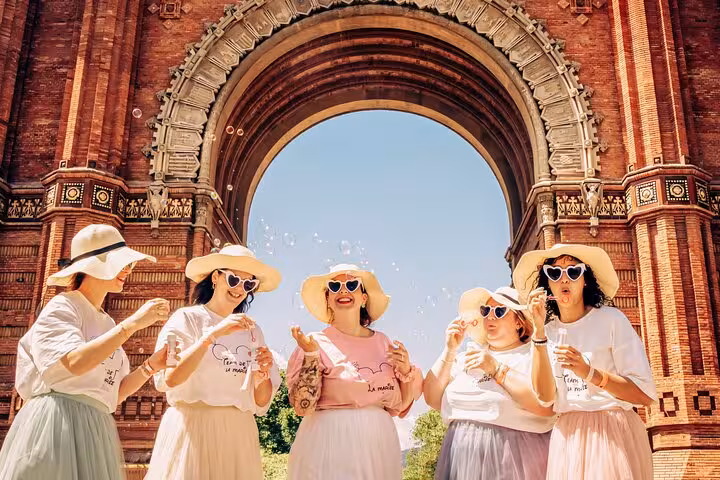 Friends in matching hats blow bubbles under Barcelona’s Arc de Triomf, a fun moment from our personal travel photoshoot.
