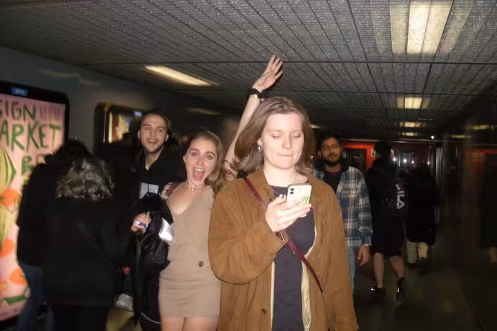 Friends walking through a vibrant Barcelona venue, celebrating with excitement and capturing the nightlife vibe.