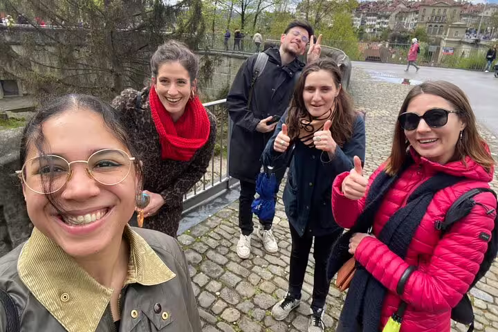 Friends posing on a bridge in Bern Old Town while doing a self-guided scavenger hunt and sights tour