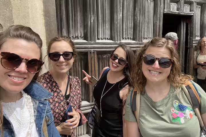 Four smiling women wearing sunglasses posing together on a Cambridge walking tour