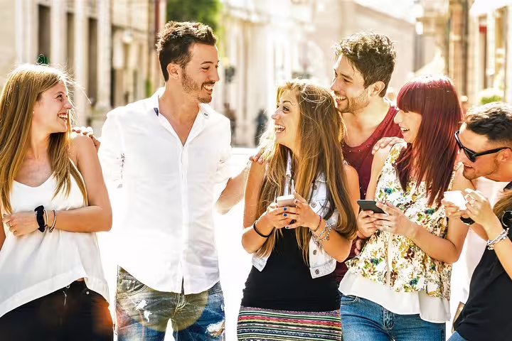 Friends laughing in Utrecht on a self-guided e-scavenger hunt, using smartphones to explore city highlights