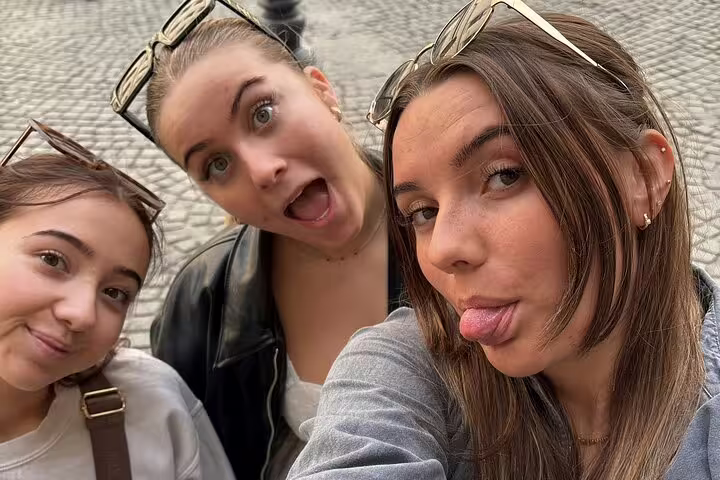 Three young women making fun faces during a walking tour in Bucharest Old Town