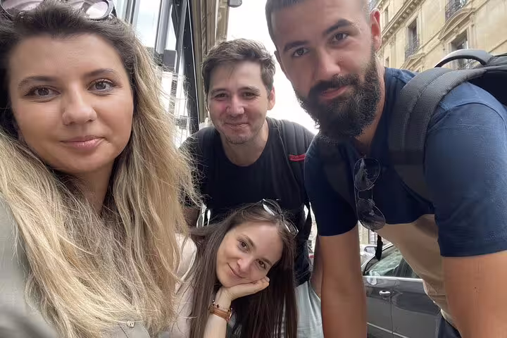 Group of four friends posing for a selfie on a Paris street during a Seine walking tour