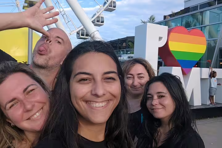 Friends pose by the I Love MTL rainbow sign on a Montréal scavenger hunt and city highlights walking tour