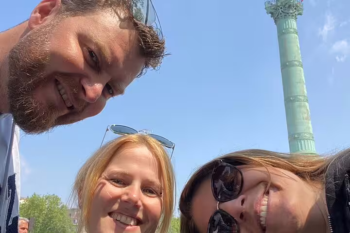 Friends smiling near the July Column at Place de la Bastille on a Marais scavenger hunt self-guided tour