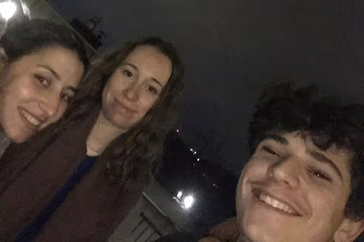 Three smiling friends on a night walking tour adventure in Lyon city