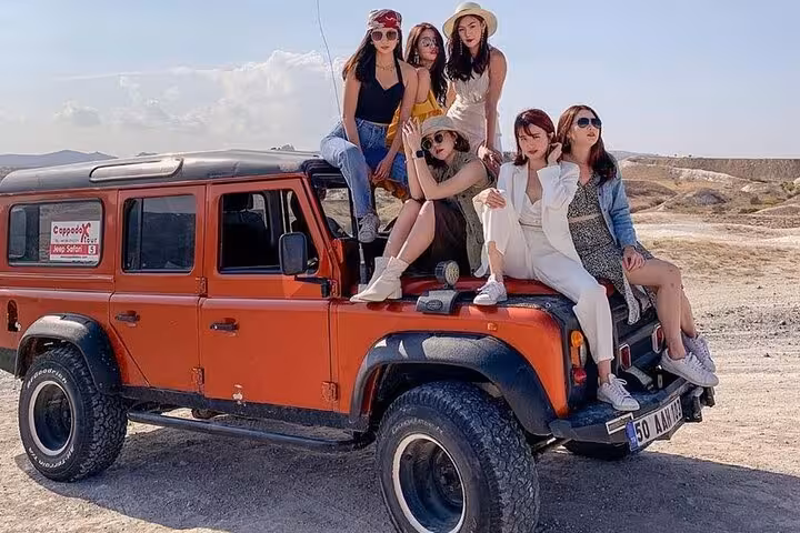Friends on red 4x4 during Cappadocia Jeep safari tour, off-road adventure across valleys and scenic viewpoints