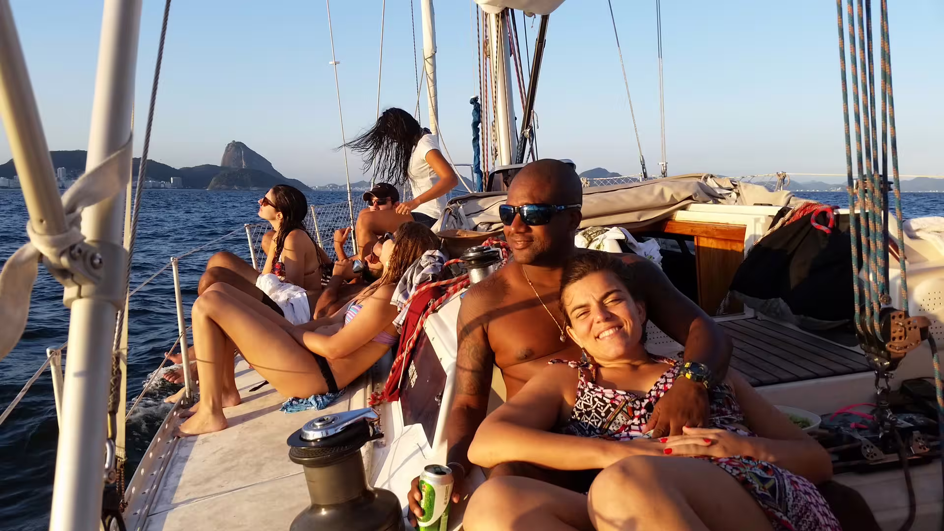 Group of friends relaxing on a sailboat during a Wake Up and Sail tour with scenic ocean views.