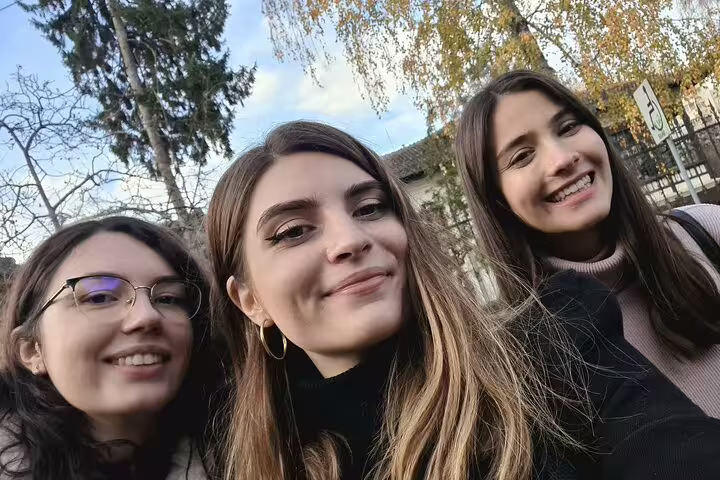 Three smiling young women taking a selfie outdoors in Bucharest Old Town during a guided tour