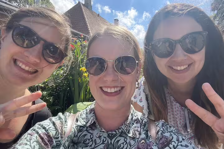Three smiling women taking a selfie outdoors making peace signs on a Copenhagen walking tour