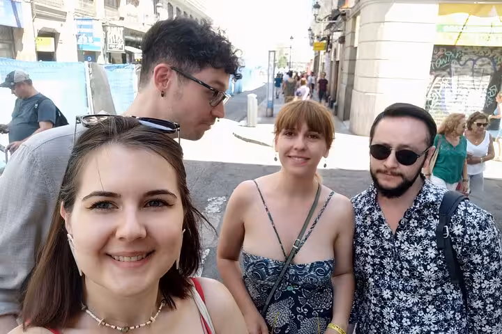 Group of four friends taking a selfie on a historic Madrid street during a ghost walking tour