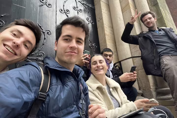 Group of five friends taking a selfie outside a historic building in Manchester