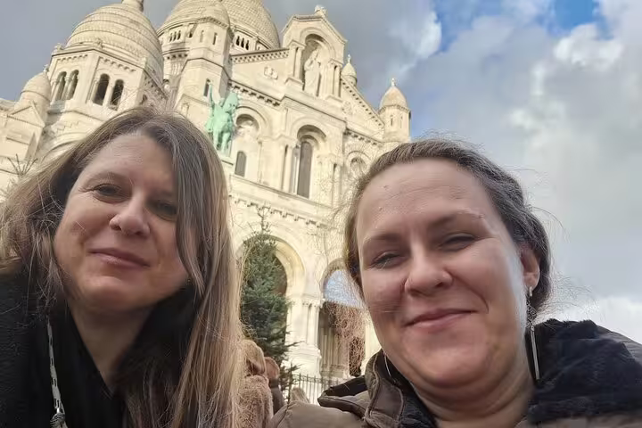 Friends selfie with Sacré-Cœur Basilica domes on Montmartre hill, Paris, on a self-guided scavenger hunt tour