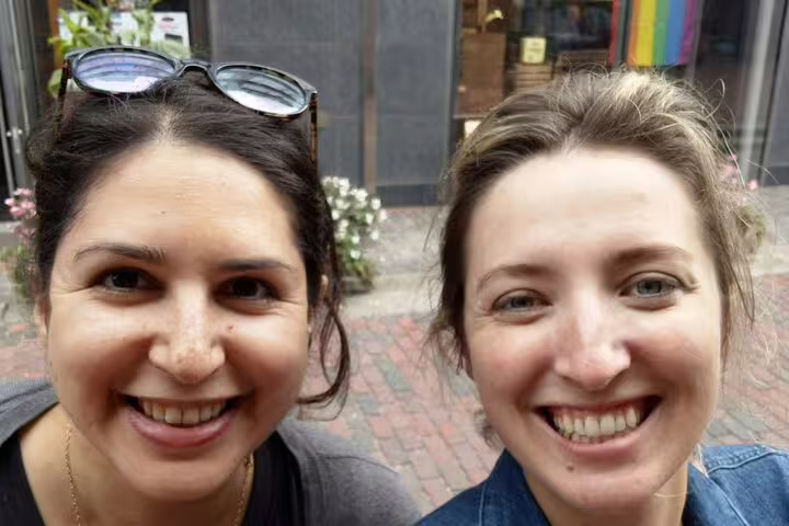 Two smiling women on a self-guided exploration tour in Toronto's Distillery District