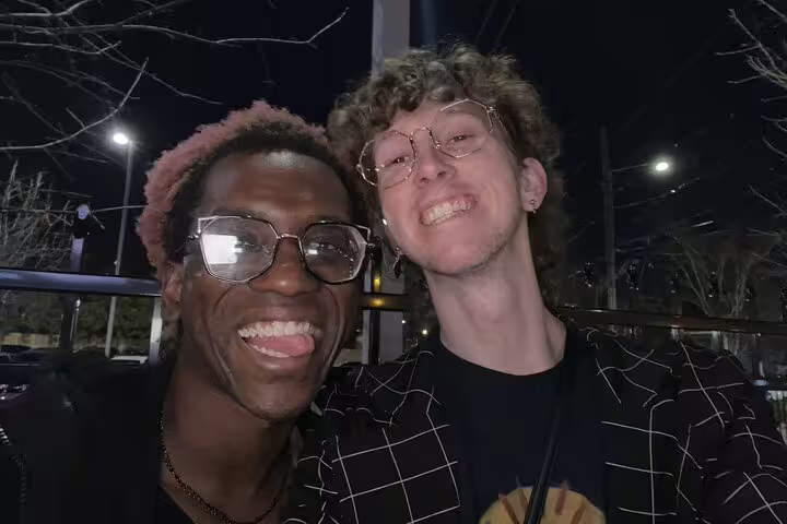 Two smiling friends posing together at night in Downtown Atlanta during a walking tour