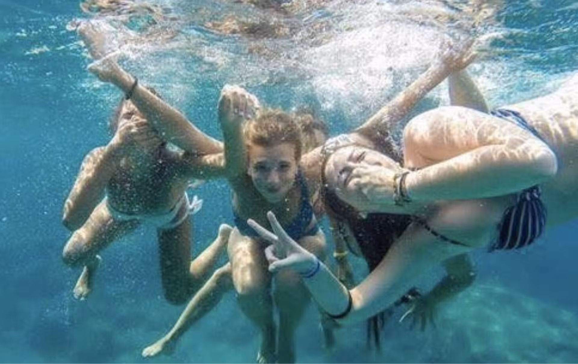 Friends posing underwater during a boat party day trip on the French Riviera near Cannes