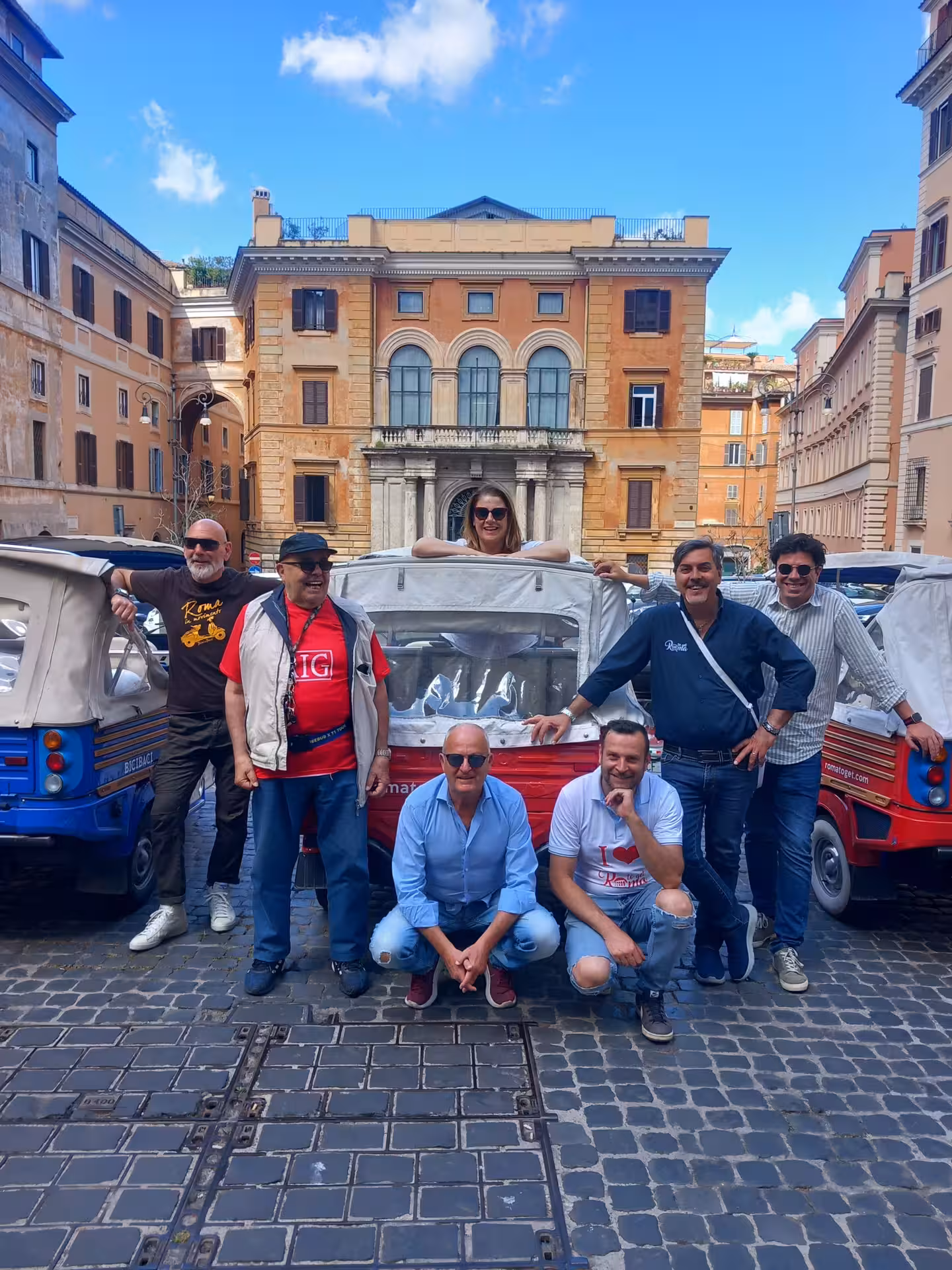 Group of friends gathers around a tuk-tuk on cobblestone streets, exploring the charming historic center of Rome.