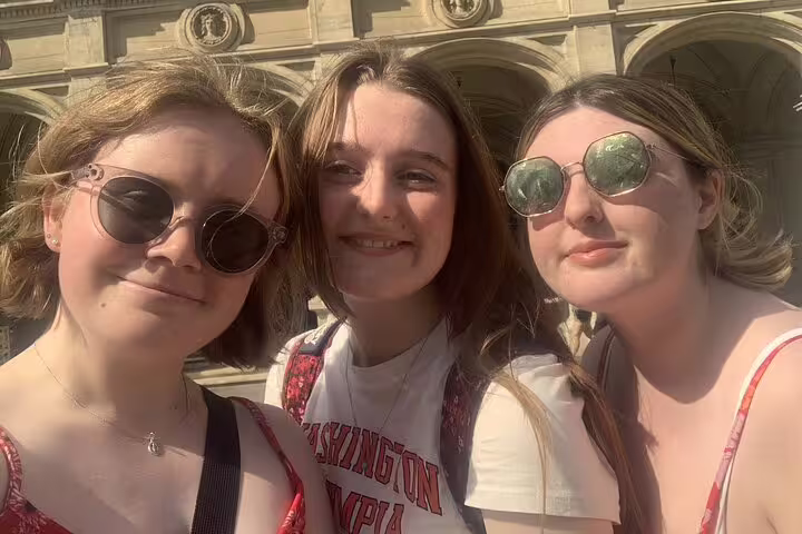 Three young women smiling together on a sunny Vienna city walking tour