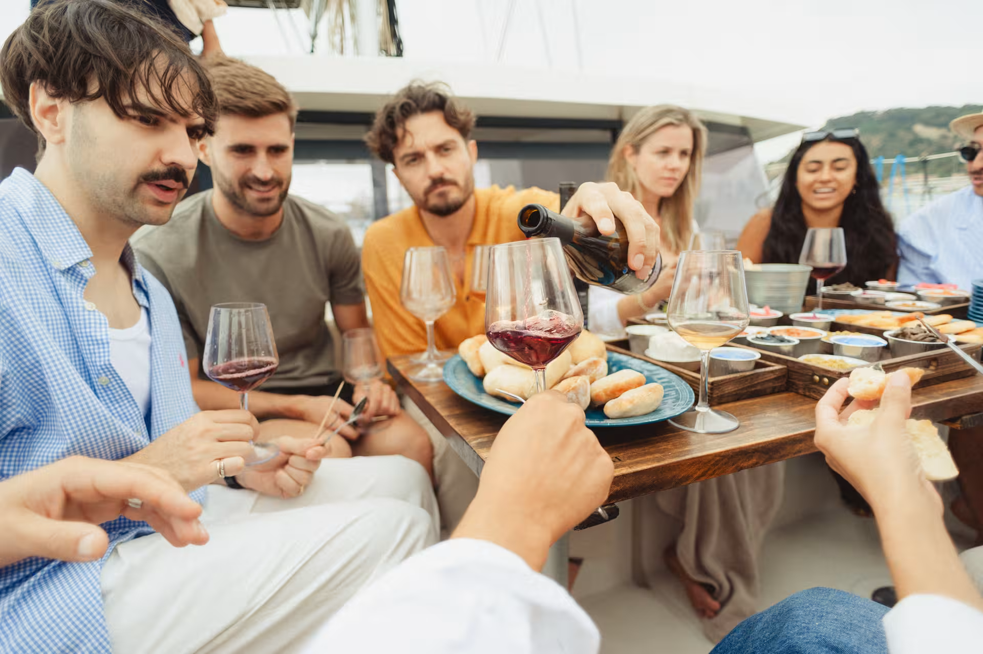 Friends enjoying Wine & Art with red wine tasting and tapas on a yacht, social sip-and-paint style experience