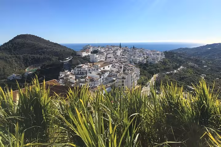 Panoramic view of Frigiliana nestled in lush green hills, offering stunning vistas on the Málaga hiking tour.