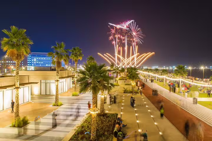 Vibrant fireworks light up the sky over a lively Fujairah boardwalk, highlighting cultural festivities on the private tour.